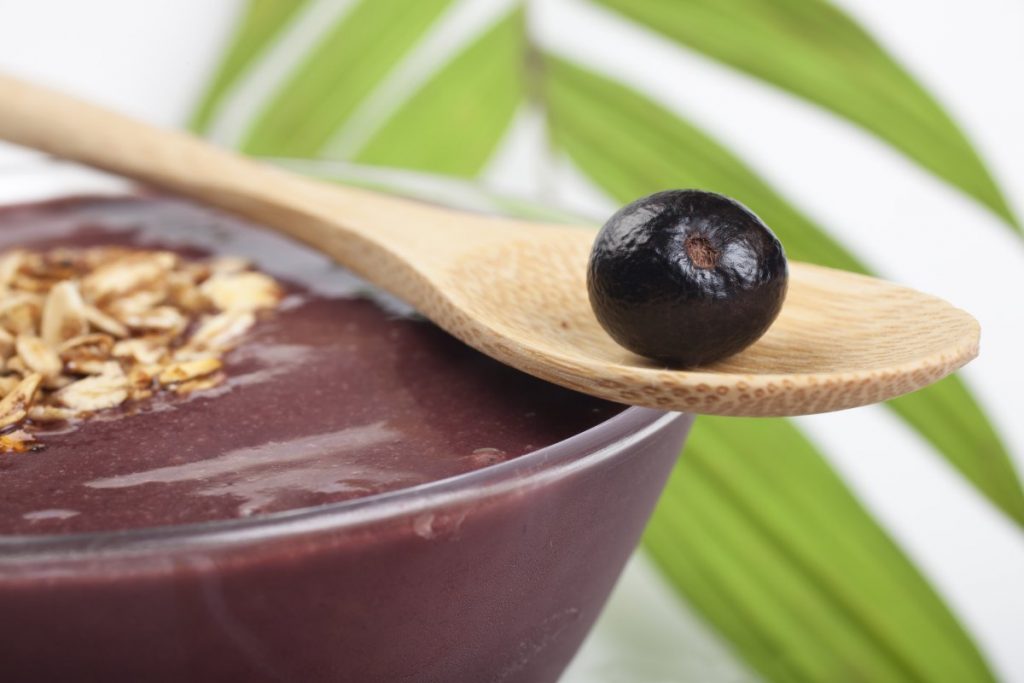 Acai berry on spoon over acai bowl