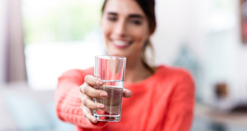 woman holding a glass of water
