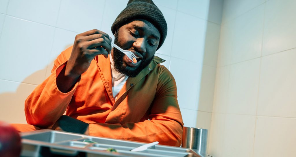 Prisoner eats food in his cell