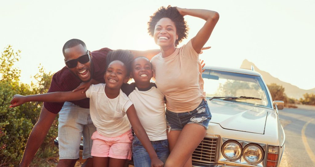 family in front of parked car on the road